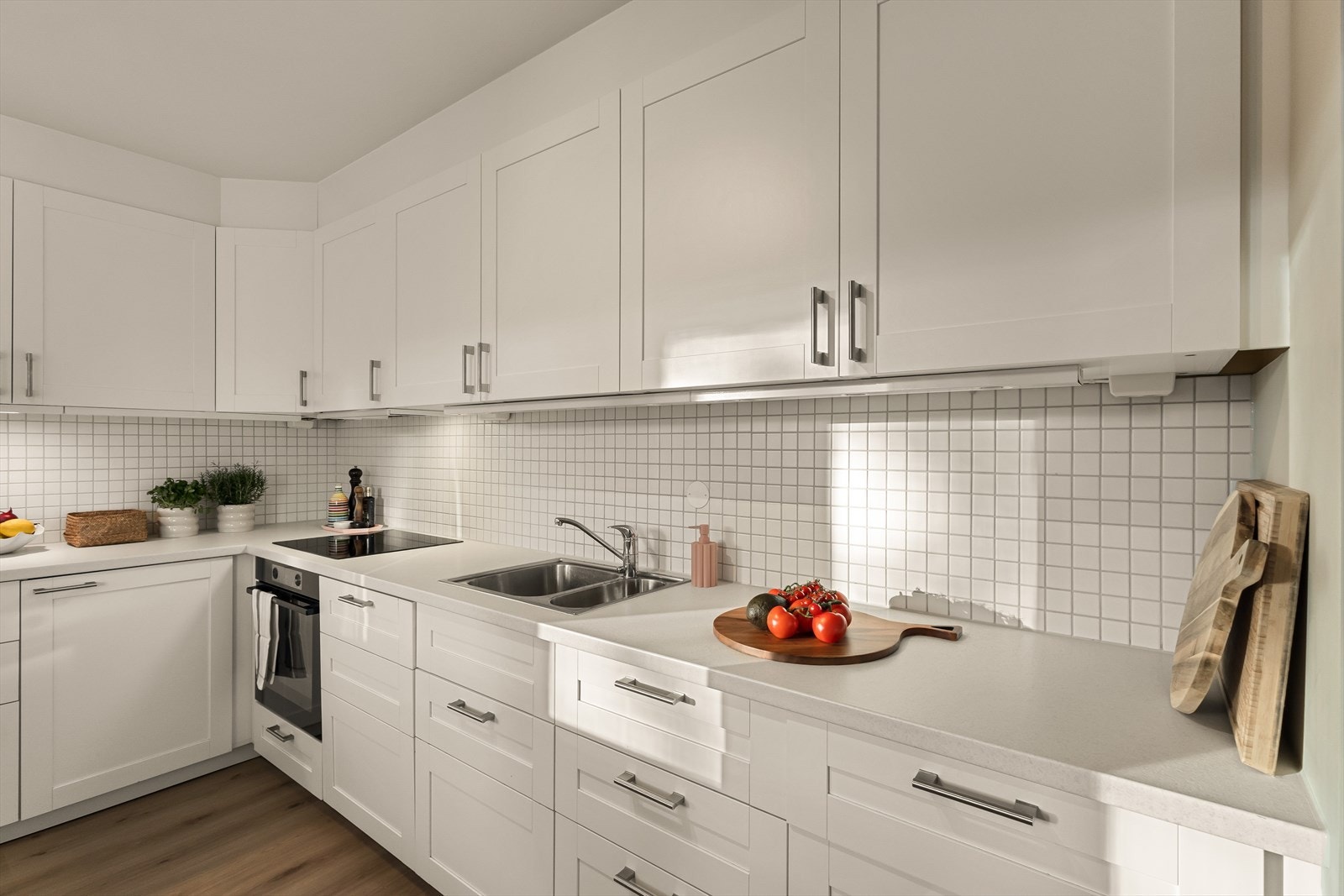 Kjøkkeninnredningen kompletteres av integrerte hvitevarer bestående av stekeovn, platetopp og oppvaskmaskin Galleribilde