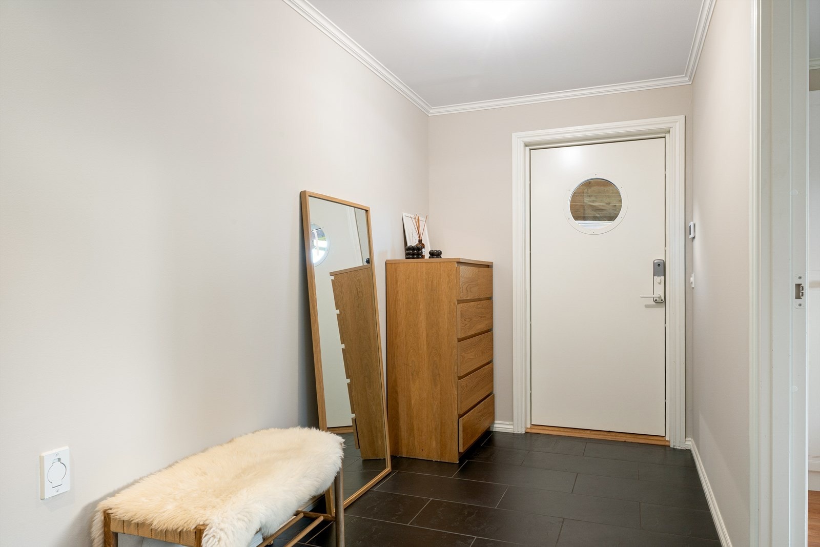 Romslig og innbydende entré med god plass til oppbevaring og slitesterkt flislagt gulv. Galleribilde