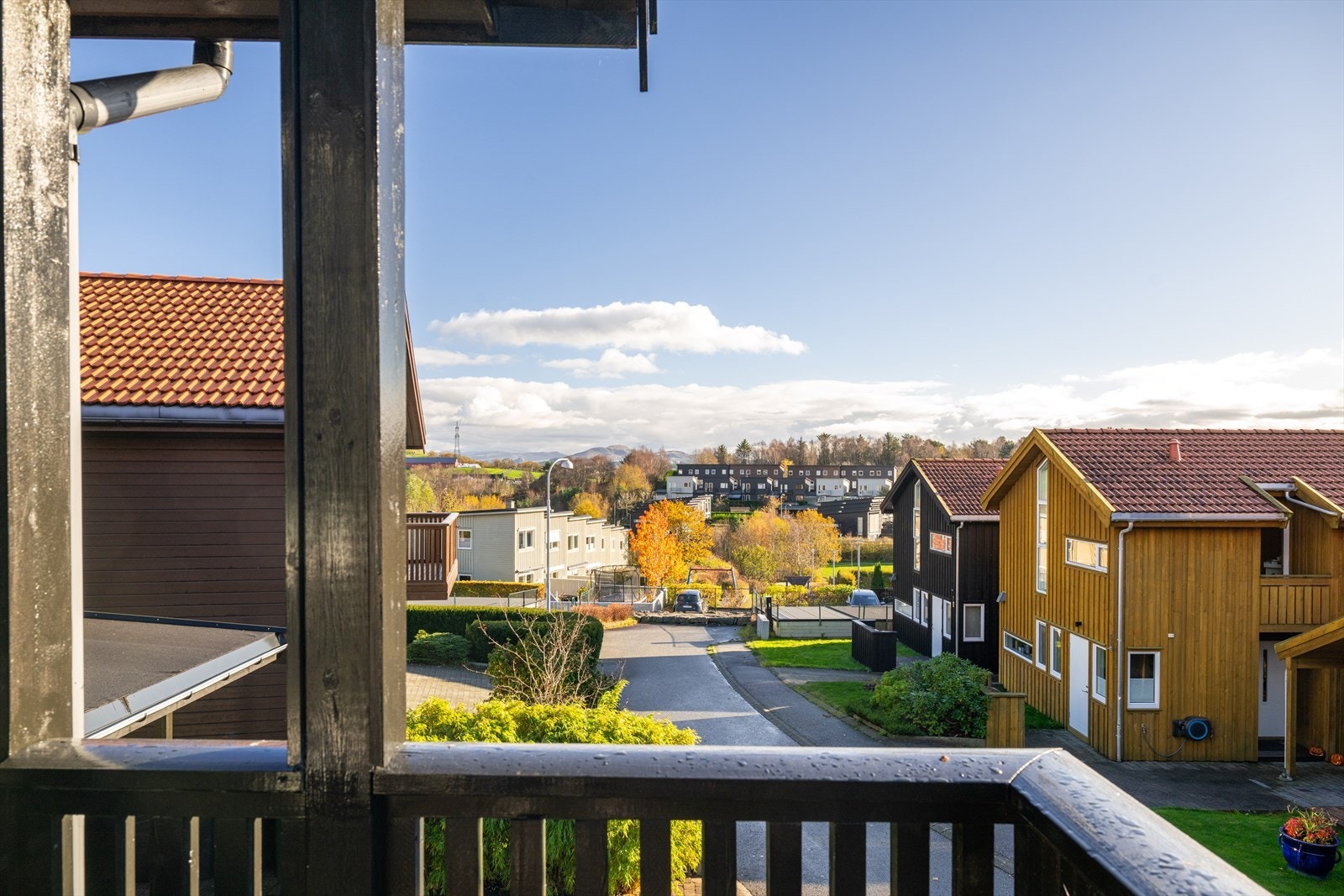 Utsikt fra balkongen mot et hyggelig og veletablert boligområde med grønne omgivelser. Galleribilde