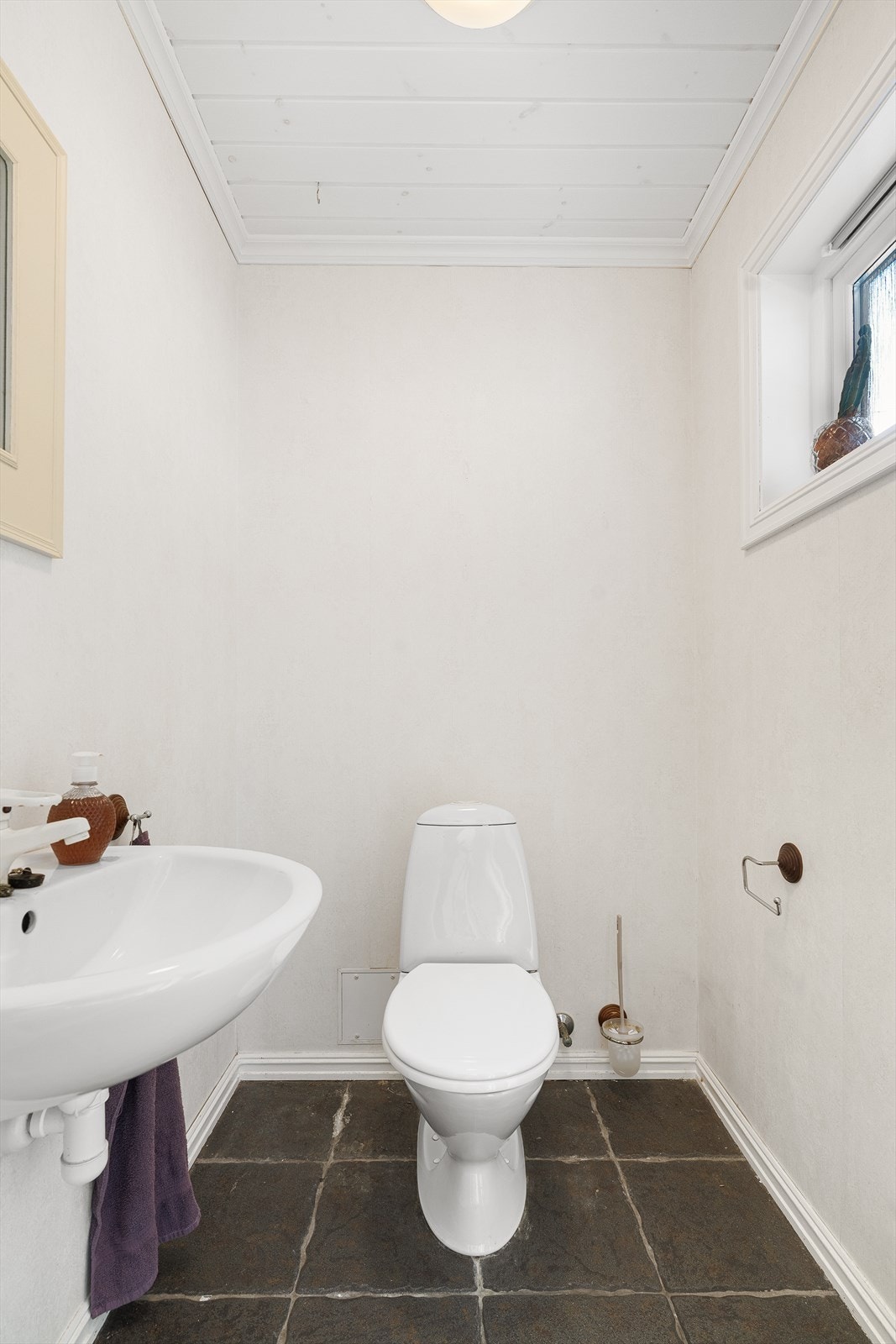 Gjestetoalett med flis på gulv. Galleribilde