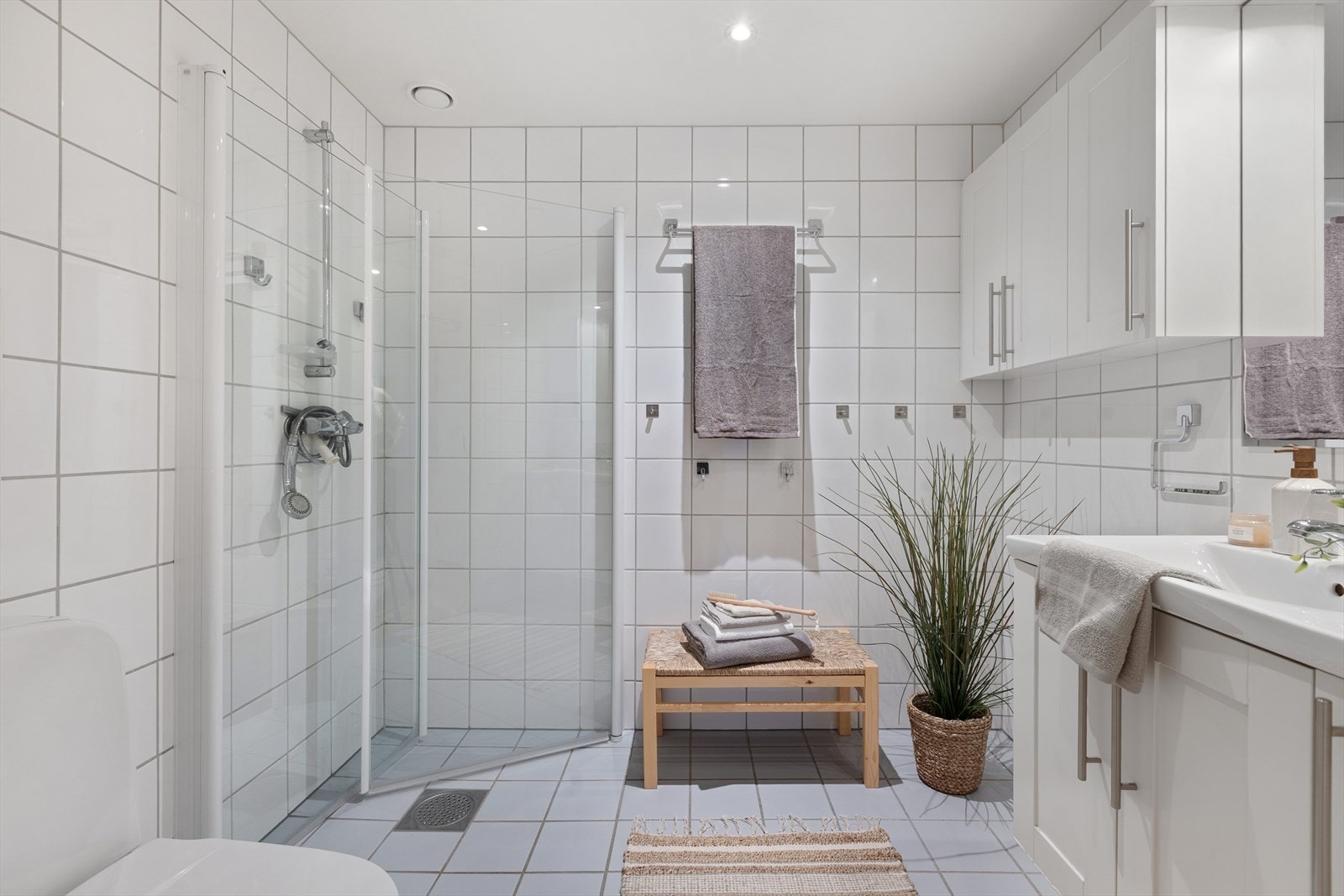 Flislagt bad med varme i gulvet. I himlingen er det downlights. Galleribilde