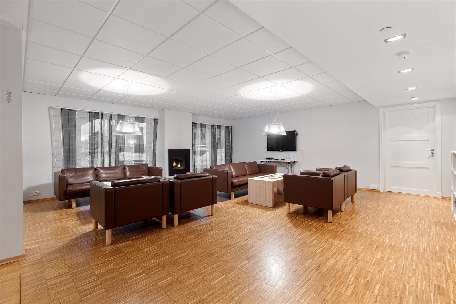 Romslig avdeling med sofagrupper, TV og gasspeis. Galleribilde