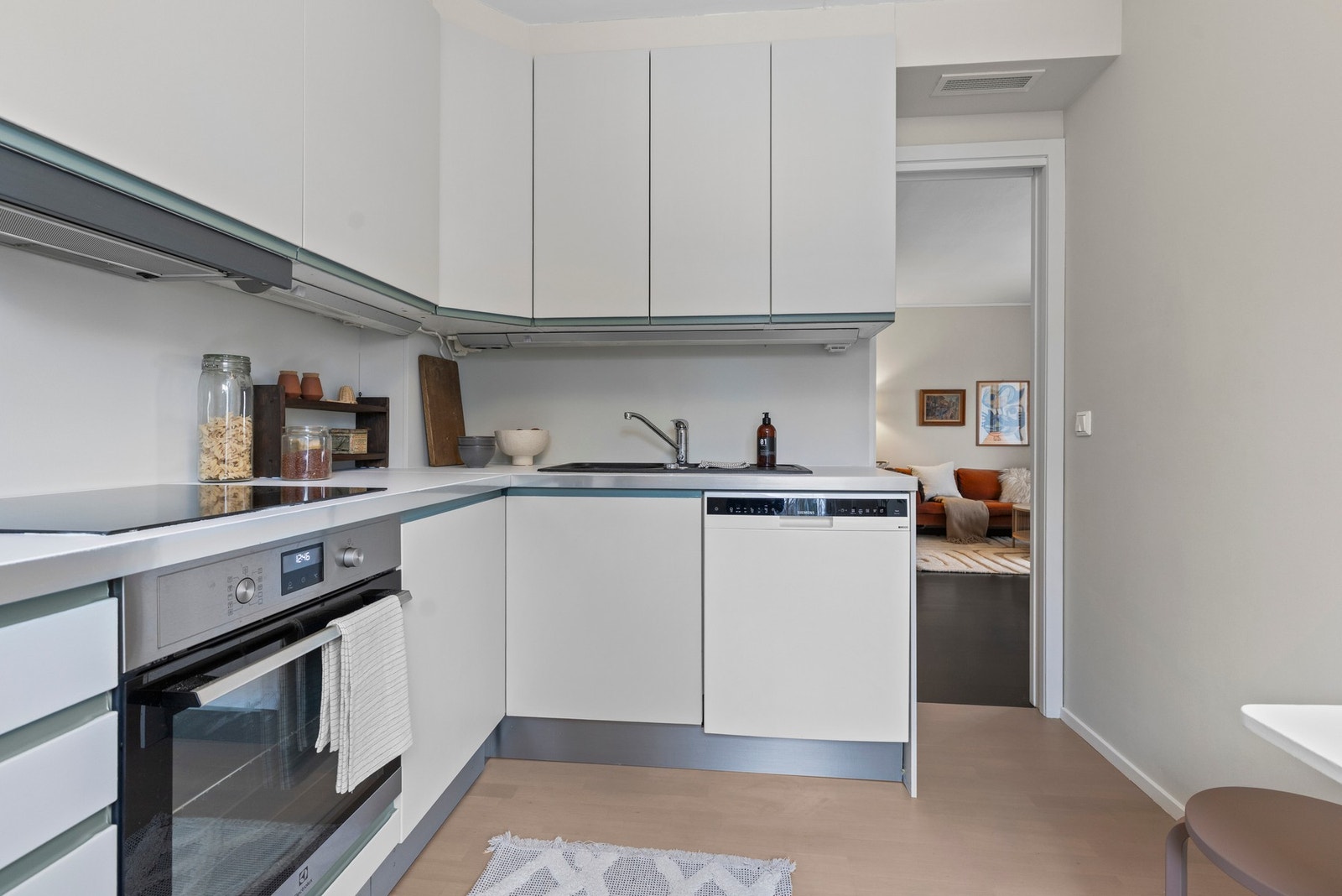 Kjøkkeninnredning med malte slette fronter og overskap med benkebelysning Galleribilde