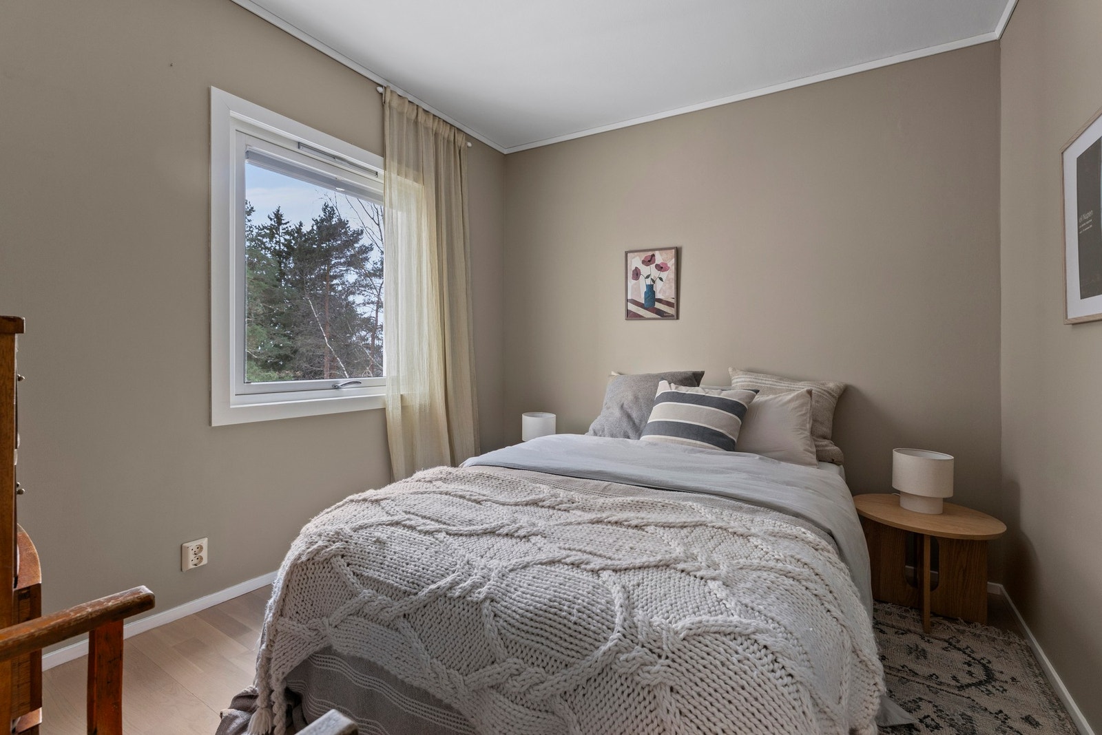 Luftig soverom med plass til dobbeltseng, nattbord og kommode Galleribilde