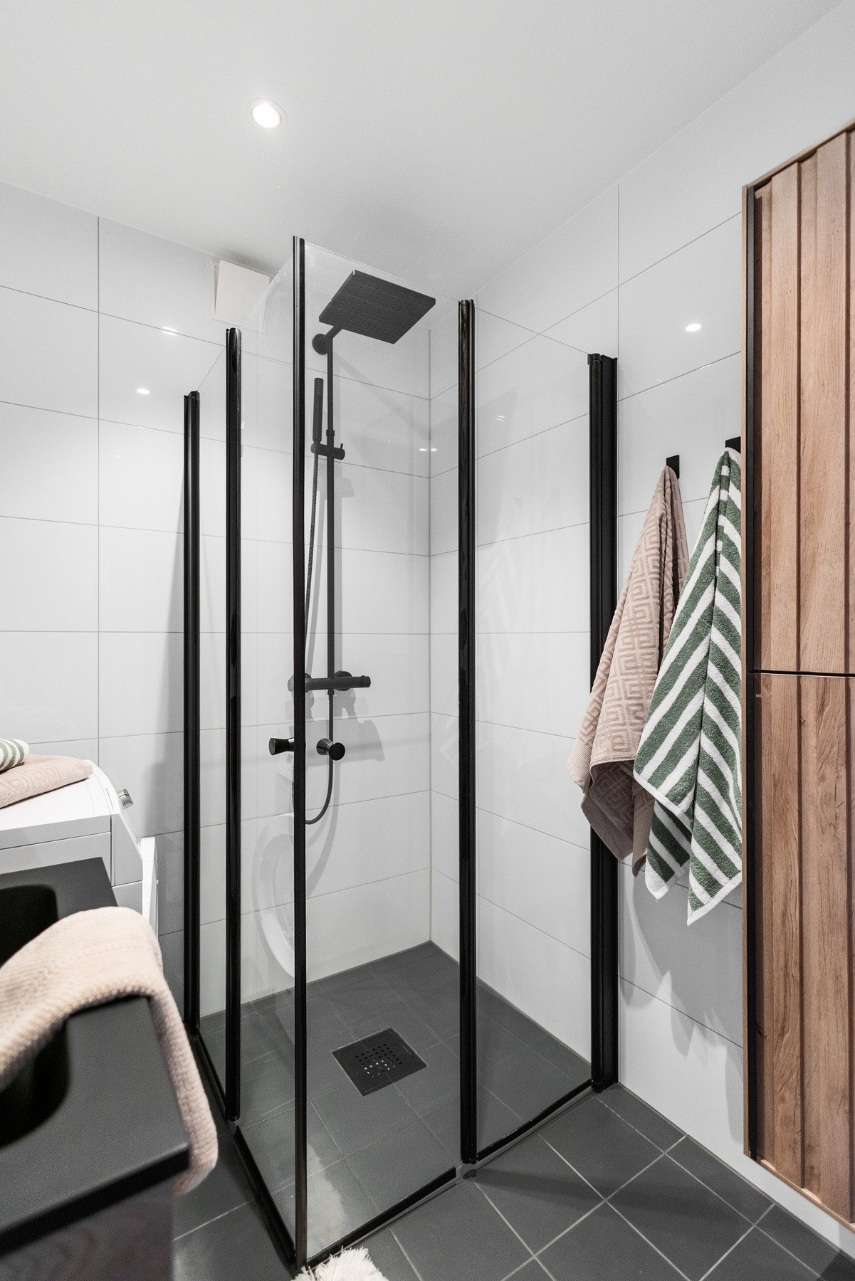 Rommet har dusjhjørne med vegger i herdet glass, servantskap med trefronter samt og heldekkende sort servantplate. Galleribilde