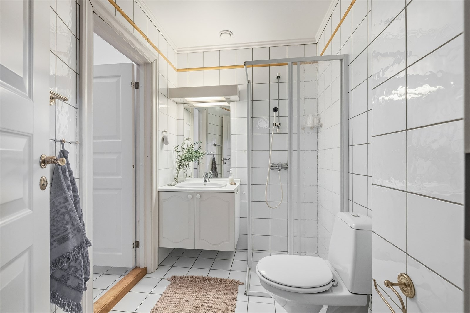 Komplett baderom med adkomst videre til et praktisk vaskerom Galleribilde