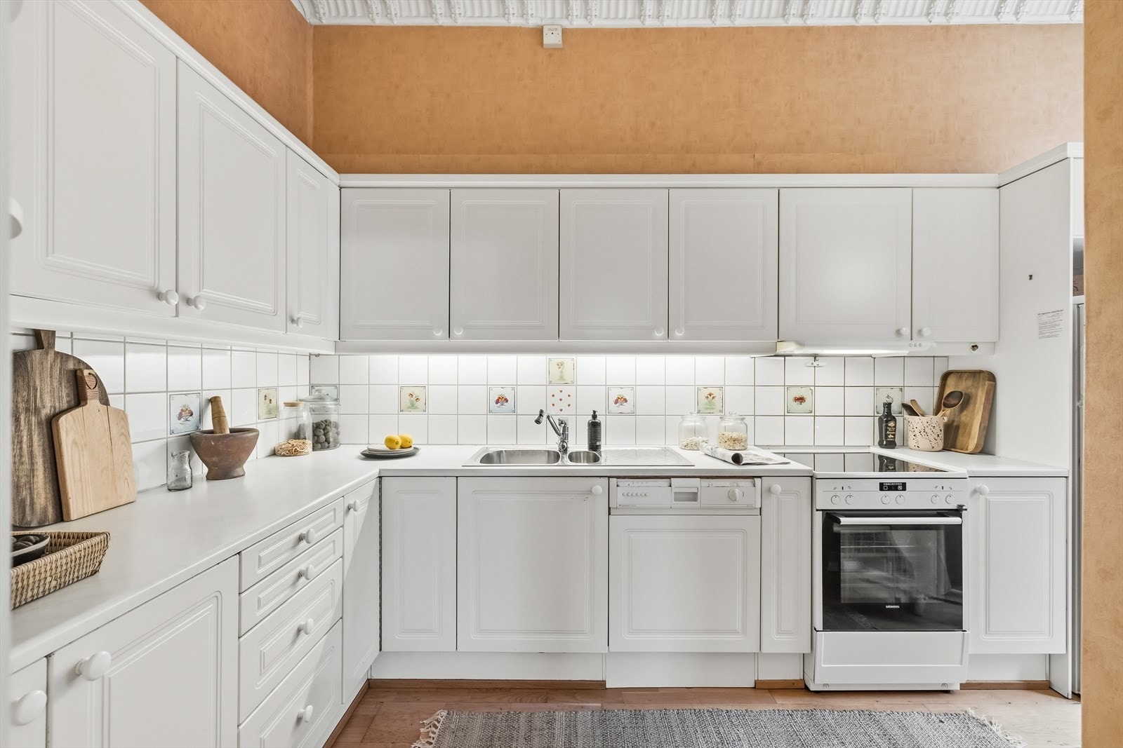 Stilrent uttrykk med fliser over benk og integrert belysning under overskap Galleribilde