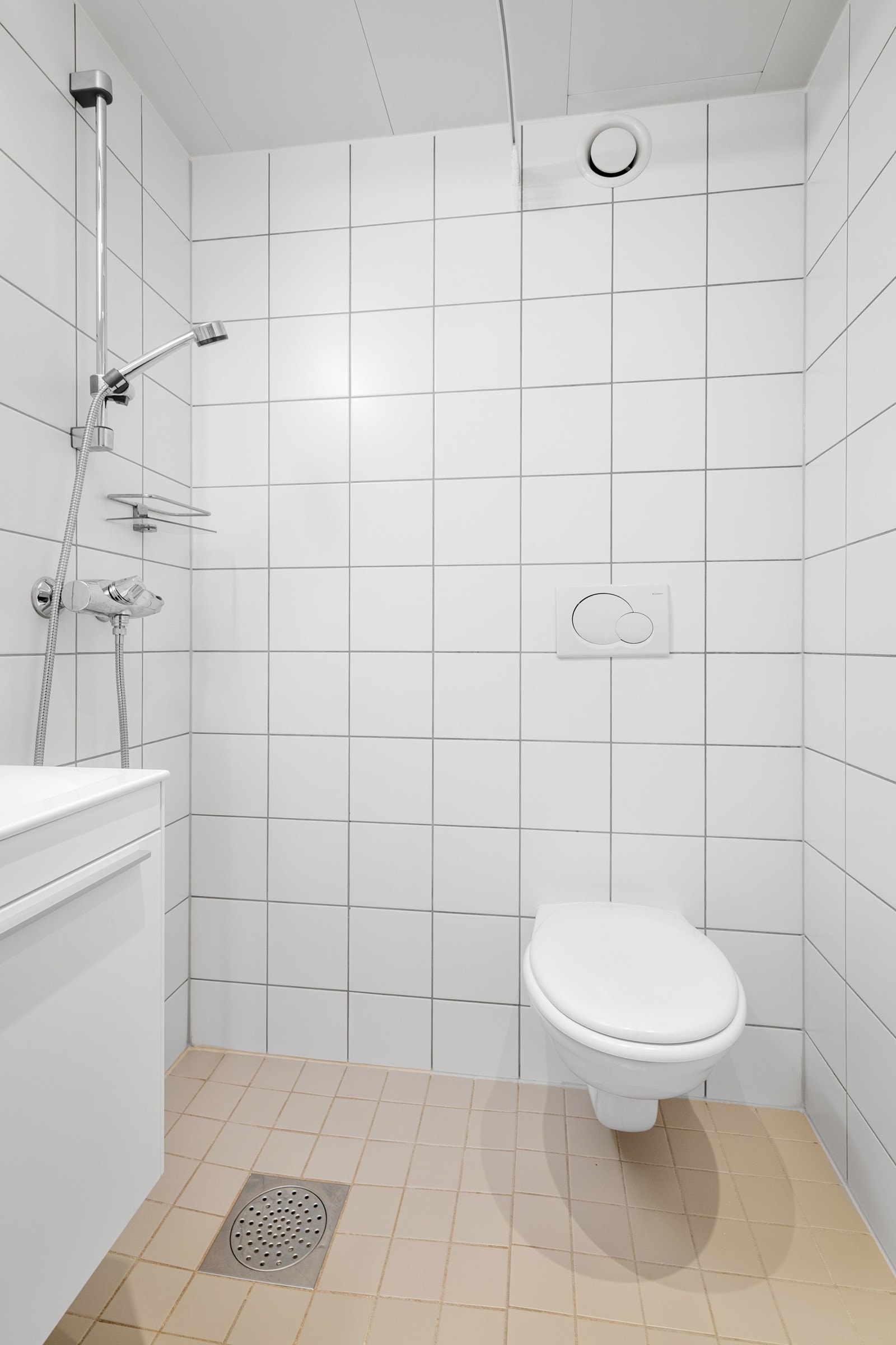 Baderommet er utstyrt med lyst servantskap med speil og belysning over, dusjhjørne med forheng og vegghengt toalett. Galleribilde