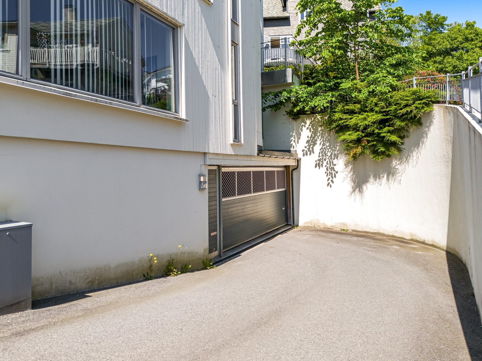 Asfaltert innkjørsel til felles garasjeanlegg under bygget. Galleribilde