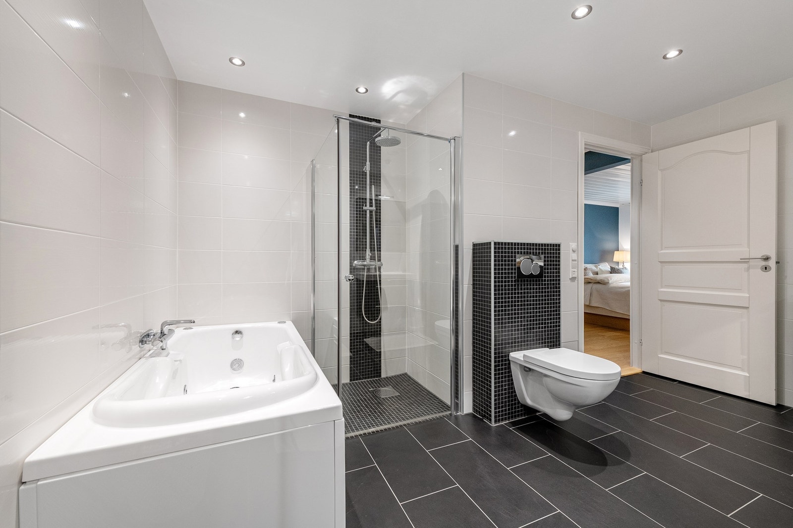 Boblebadekar, dusjhjørne med glassvegger og vegghengt dusjarmatur med hånddusj og regndusj. Vegghengt toalett Galleribilde