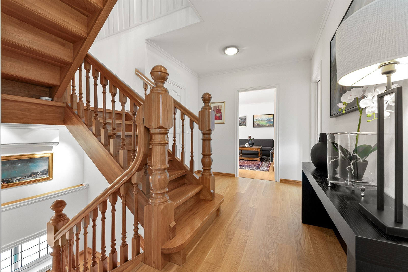 Hall/trapperom i hovedetasjen. På gulv er det lagt en-stavs eikeparkett, lyse malte vegger og malt tak. Hvite profilerte innerdører. Innvendige trapper mellom etasjene ble byttet i 2005 til heltre eiketrapper. Galleribilde