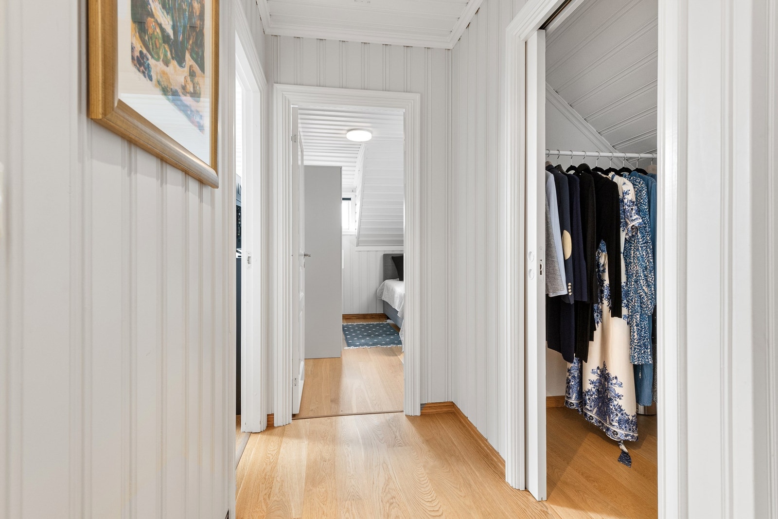 Gang i loftsetasjen med eikeparkett på gulv, malte panelte vegger og tak. Galleribilde