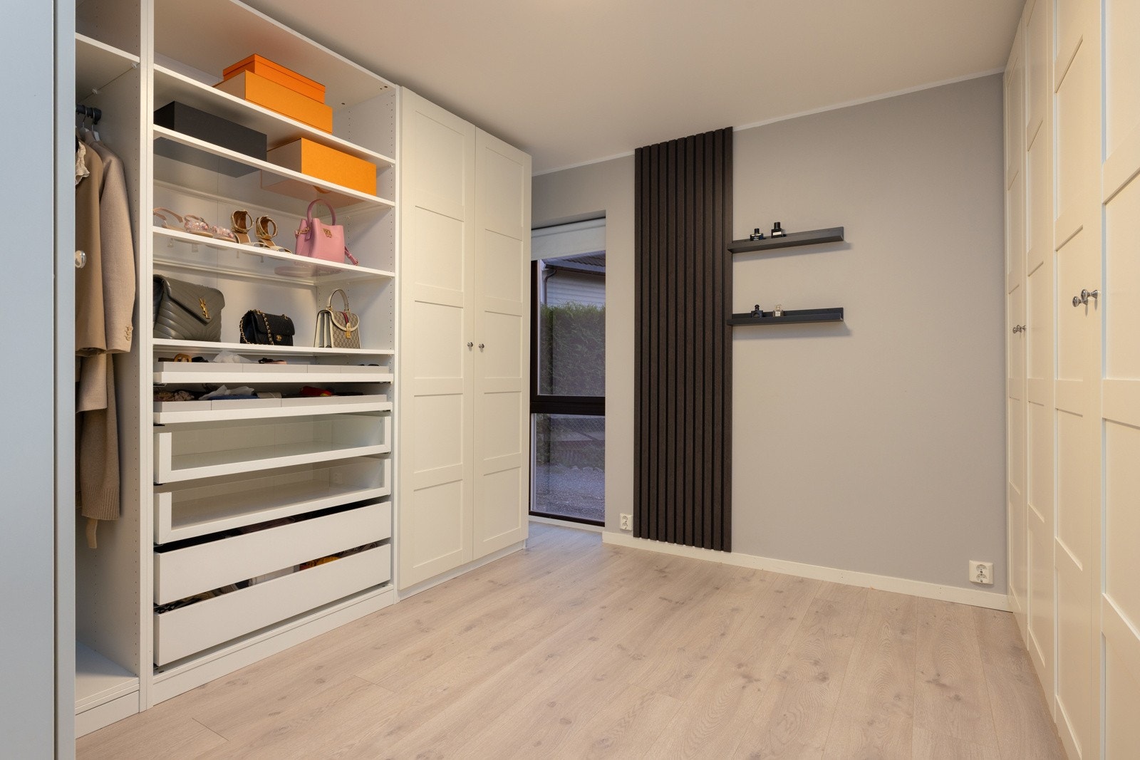Moderne og somlig soverom, skap med skyvedører, åpne hyller og elegant lys parkett. Galleribilde