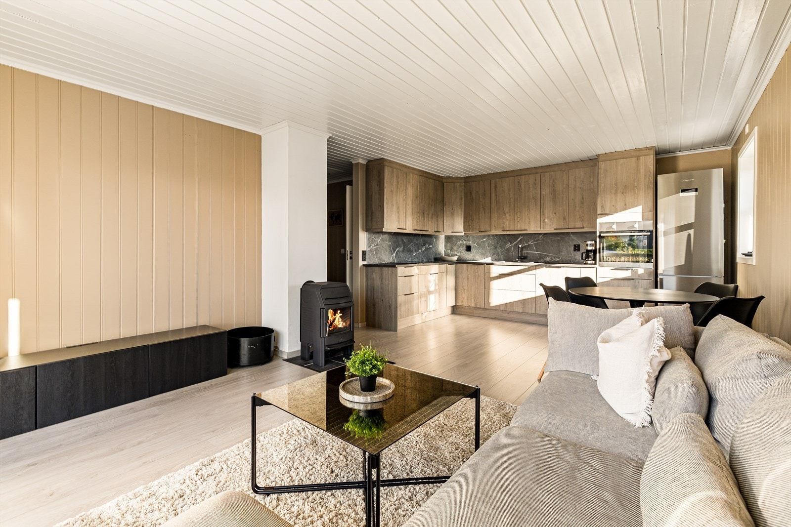 Stuen byr på god plass til møblering etter eget ønske og behov. Den åpne løsningen mot kjøkkenet skaper en sosial og luftig atmosfære, perfekt for både hverdagsliv og hyggelige sammenkomster. Galleribilde