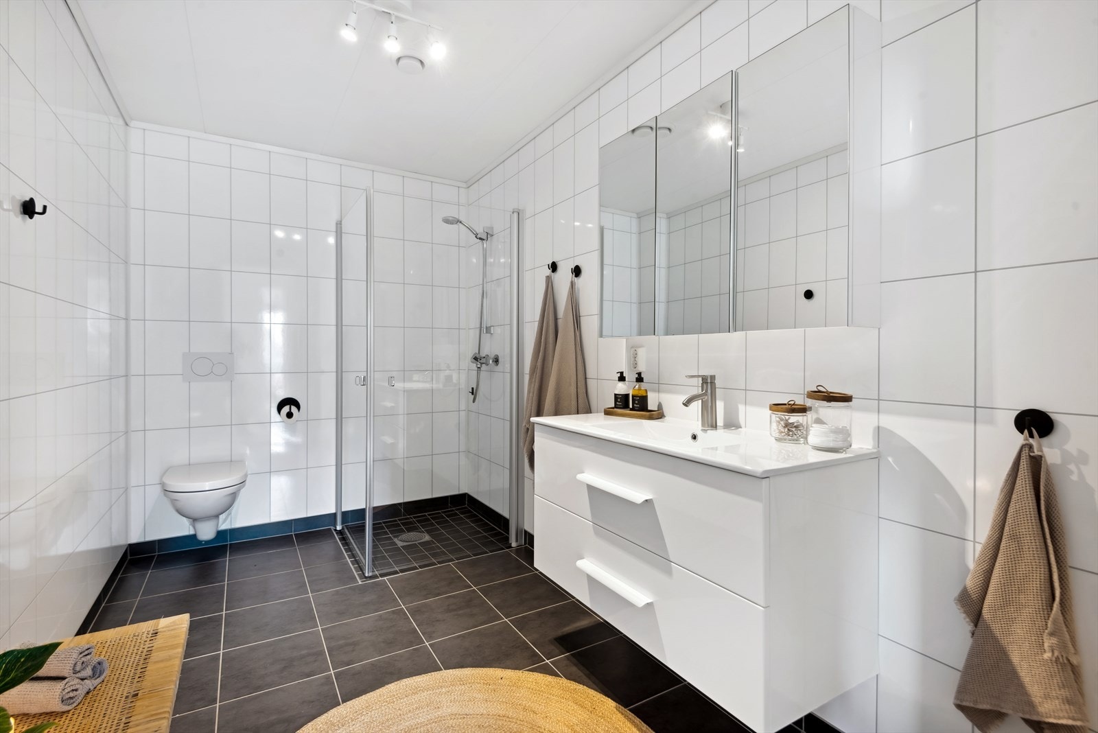 Innredningen består av et dusjhjørne, vegghengt toalett og en baderomsinnredning med nedfelt servant . Ventilasjonen ivaretas av avtrekk fra det balanserte ventilasjonsanlegget med tilluft gjennom dørspalte, noe som sikrer gode luftforhold i rommet. Galleribilde