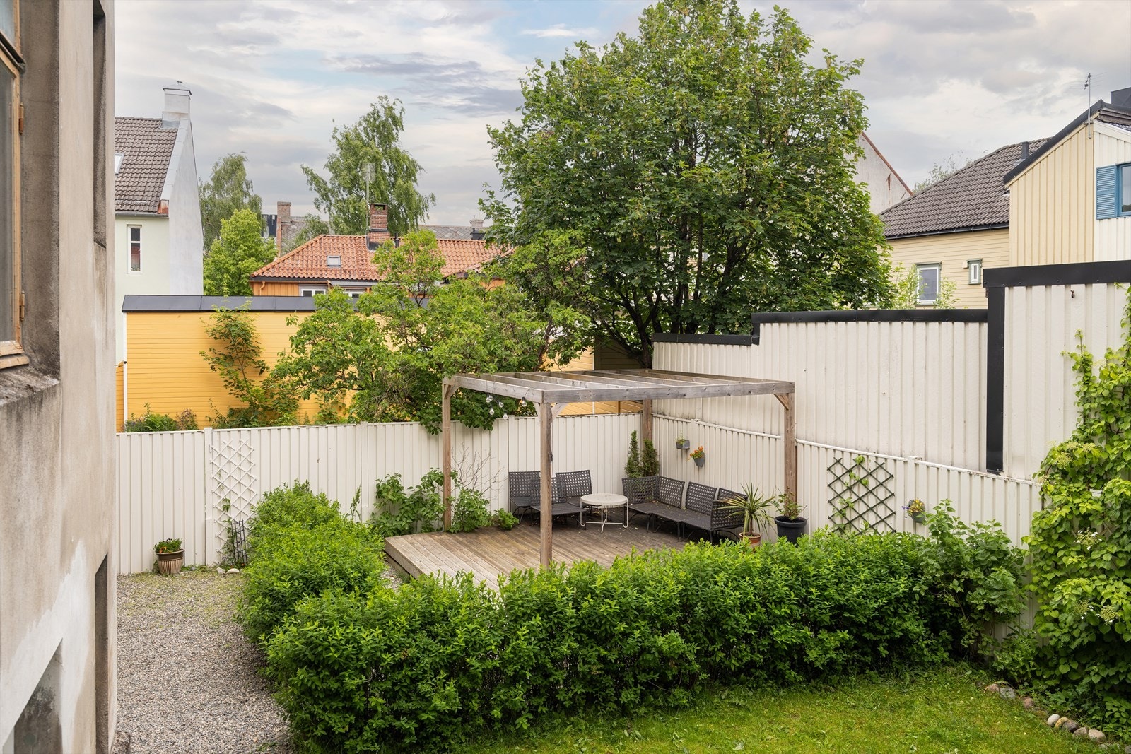 Frodig felles bakgård med platting, sitteplasser og pergola. Bakgården kan brukes fritt av beboerne. Det er også sykkelstativer i bakgården. Galleribilde