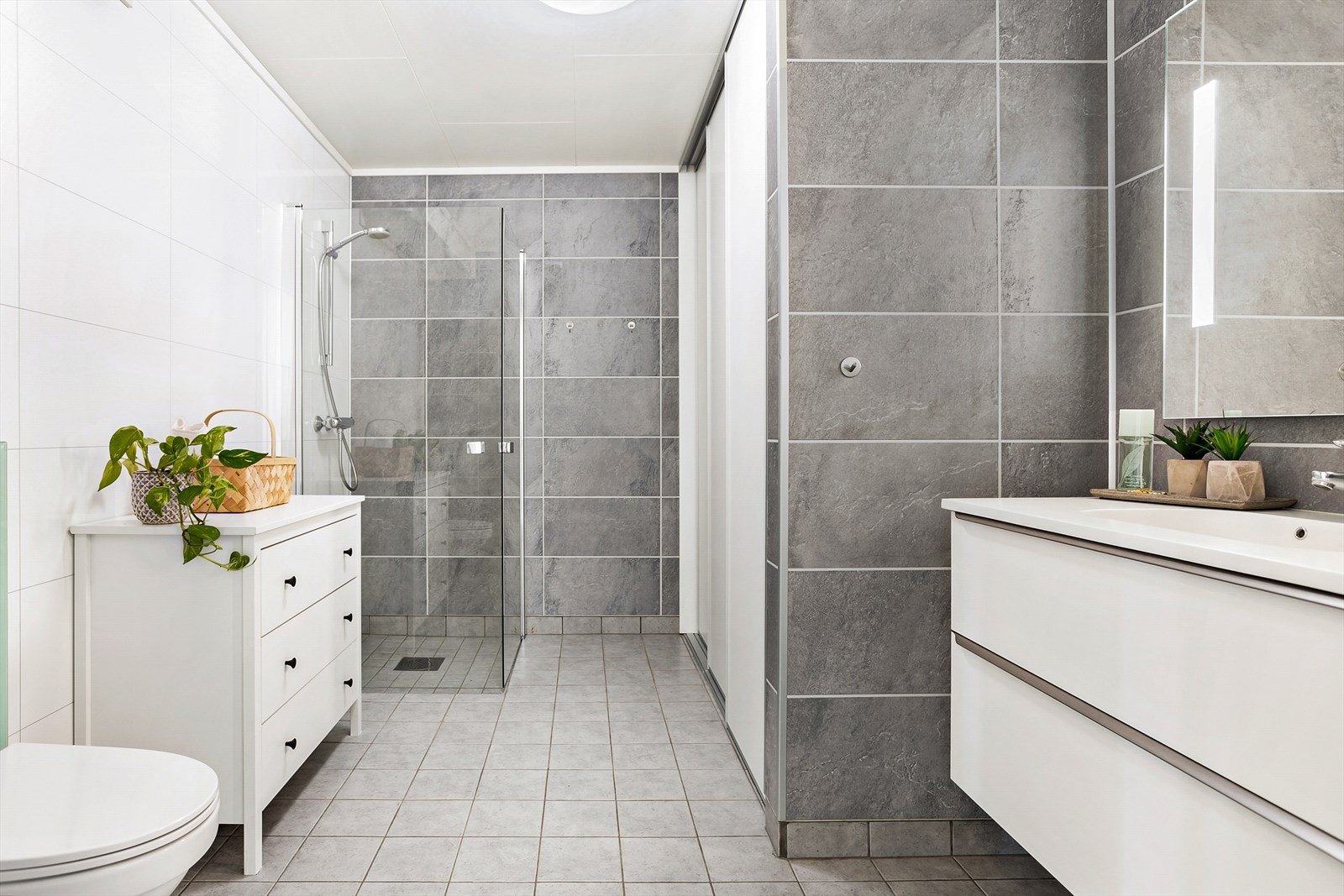 Badet er på 8,5 kvm og det er montert skyvedørsgarderobe som skjuler bla vaskemaskin og tørketrommel Galleribilde