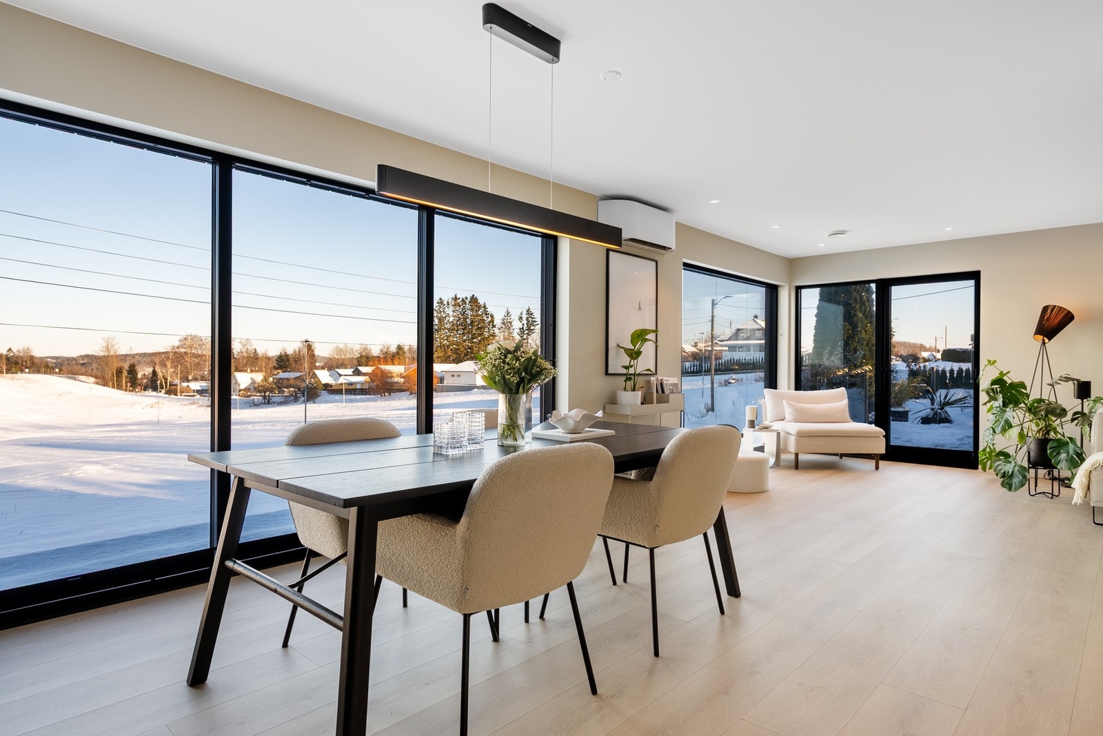 Lyse og åpne oppholdsrom og vinduer fra gulv til tak som rammer inn det landlige utsynet Galleribilde