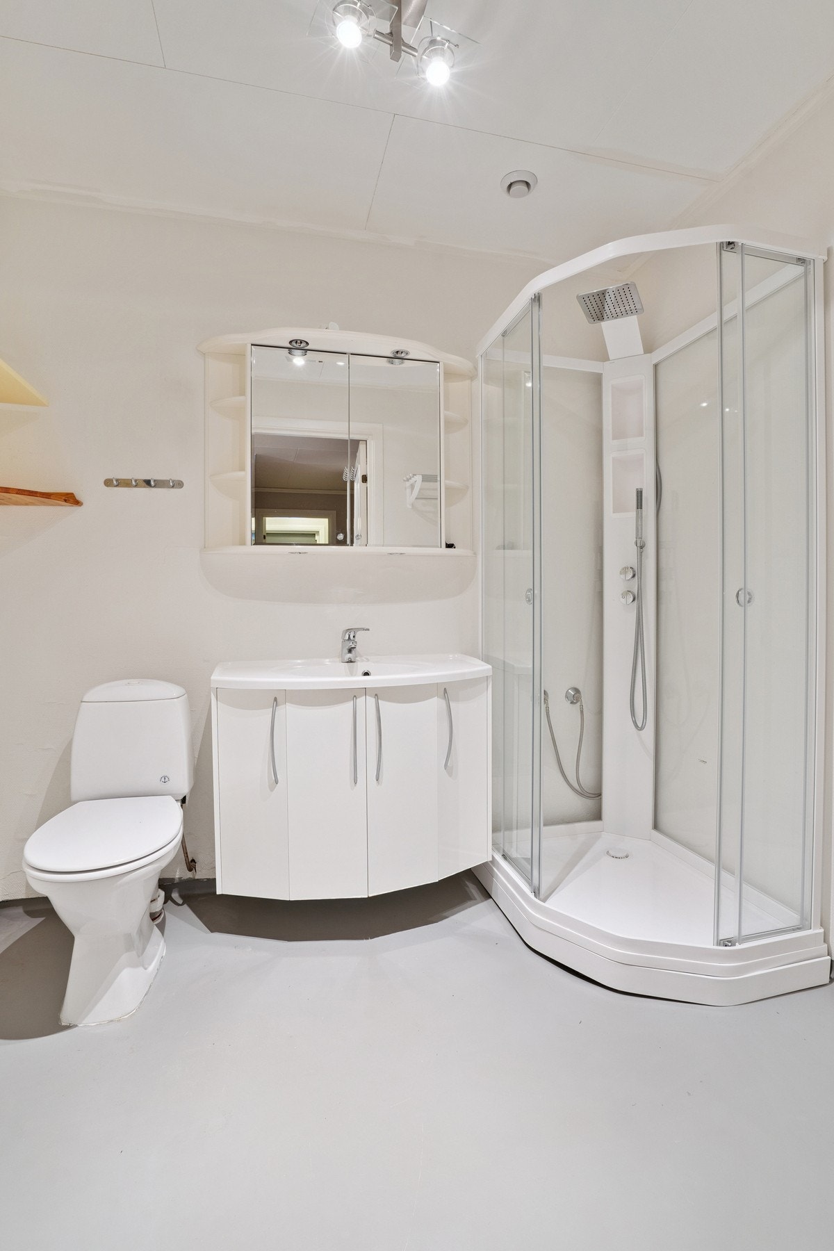 Eldre bad med toalett, dusjkabinett, vask og baderomsinnredning. Galleribilde