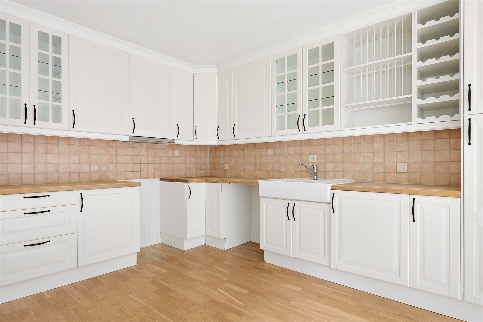 Innredningen har hvite profilerte fronter, benkeplate i tre og en dobbel oppvaskkum i porselen. Galleribilde