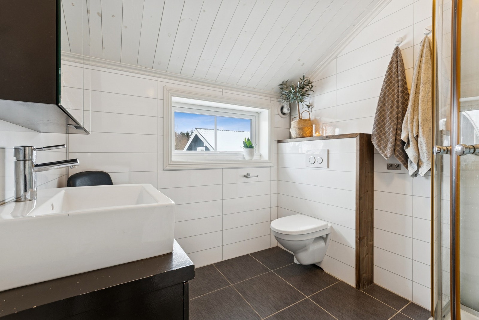 Badet har flislagt gulv med vannbåren varme og baderomsplater på veggene. Galleribilde