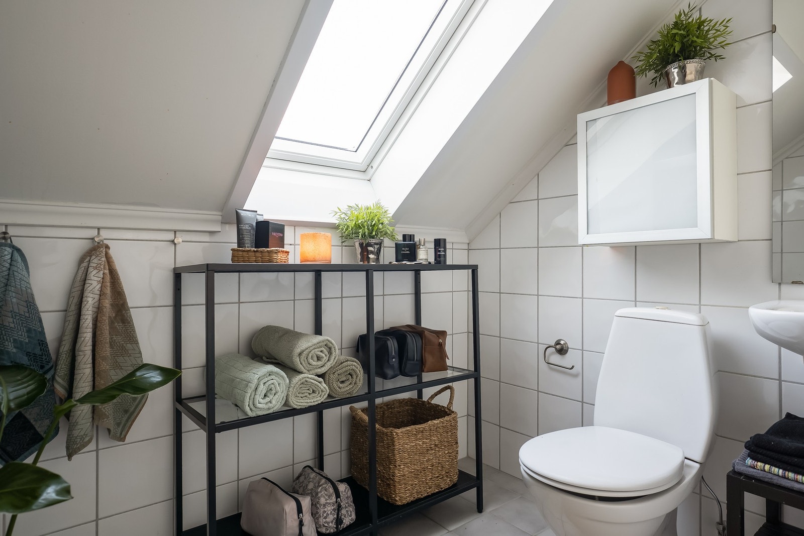 Badet innehar gulvvarme i flislagt gulv, samt flislagte vegger. Flotte løsninger til oppbevaring og oppheng til håndduker. Galleribilde