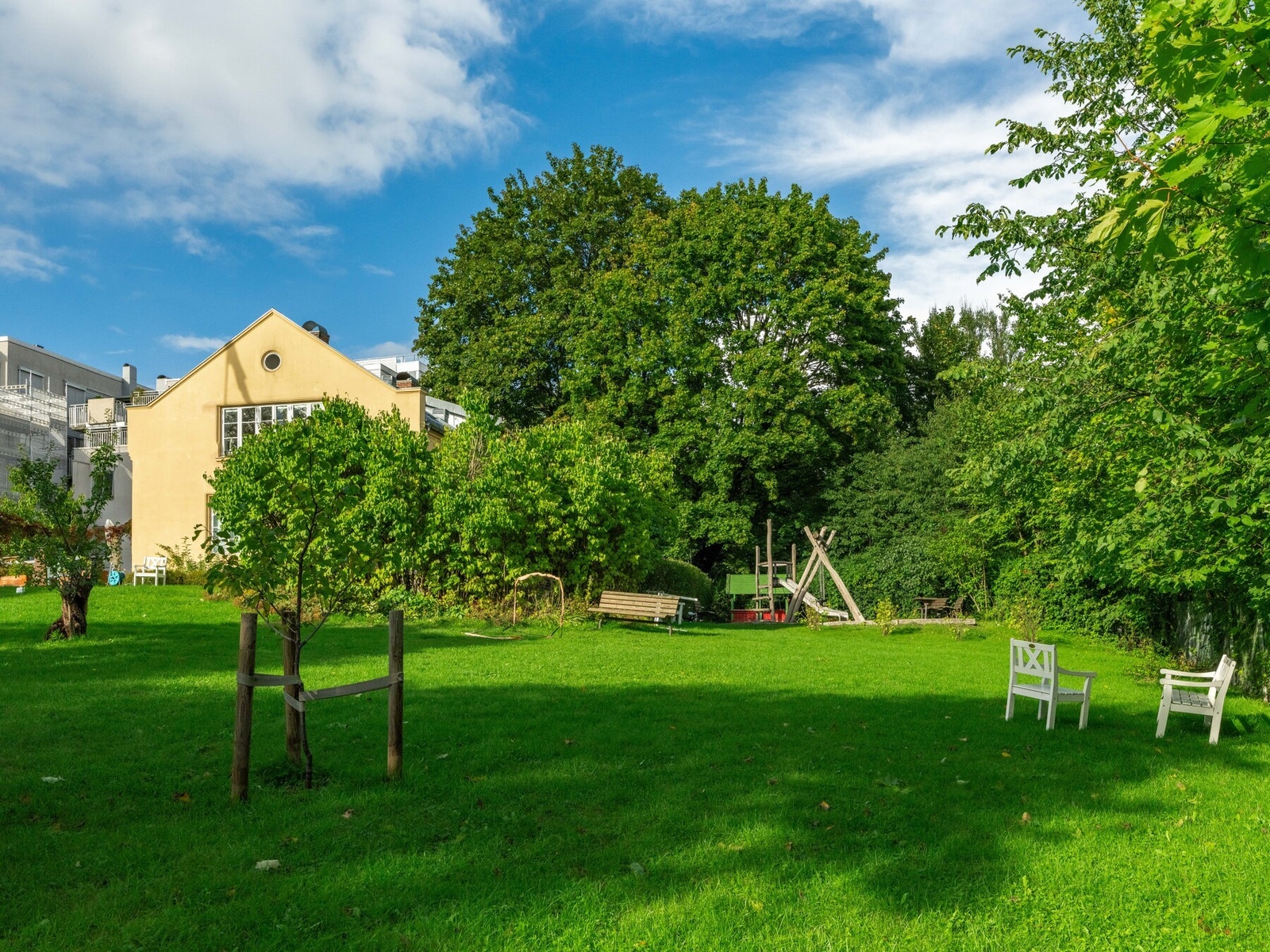 Anerkjent bakgårdshage med sittegrupper på sommerstid. Galleribilde