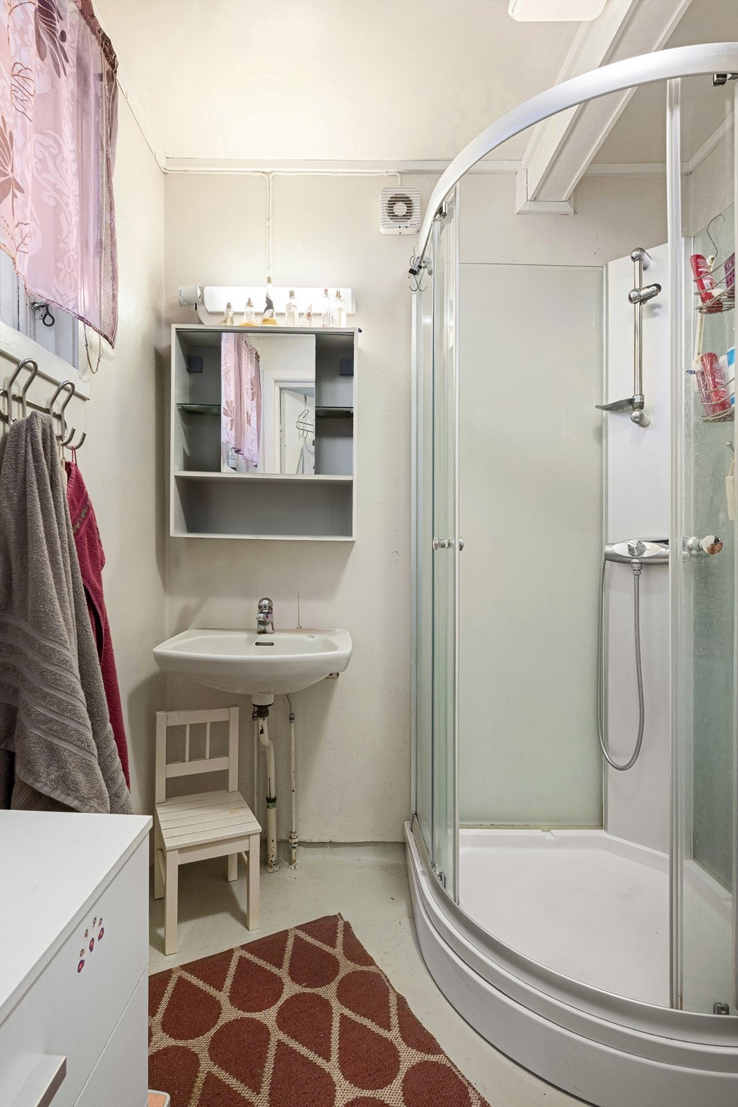 Badet er av eldre dato og inneholder servant, speilskap, dusjkabinett og opplegg til vaskemaskin. Galleribilde