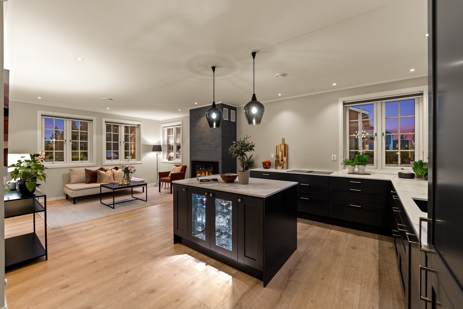 I midten av kjøkkenet er det plassert en funksjonell og fin kjøkkenøy med vitrinedører. Galleribilde