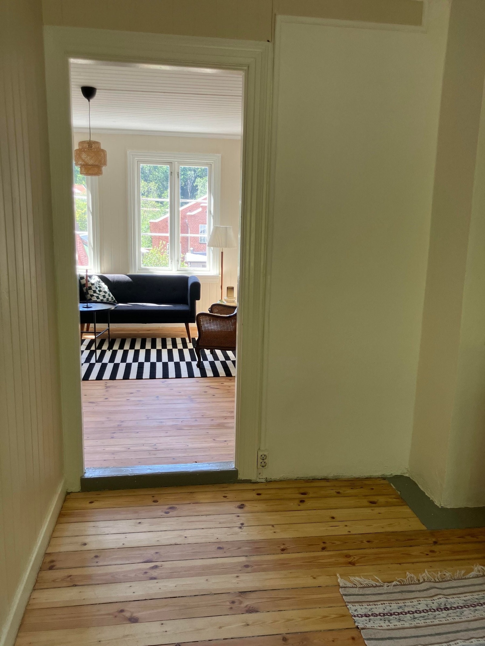 Fra kjøkken inn til stue med lys fra store vinduer på begge sider Galleribilde