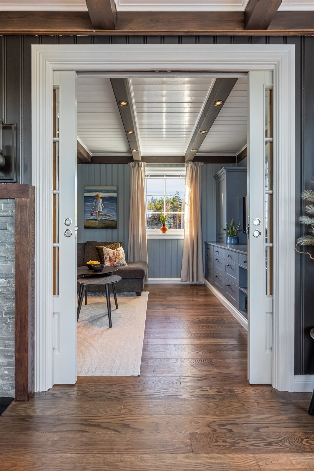 Fra stuen er det stor åpning med doble skyvedører inn til tv-stuen Galleribilde