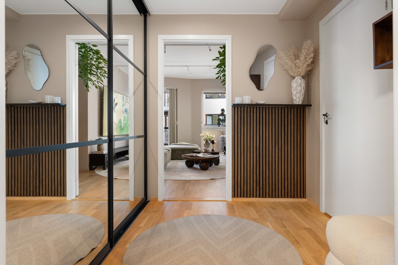 Entréen er romslig og innredet med skyvedørsgarderobe med speilfronter. På den ene veggen er det etablert et spileelement som tilfører rommet et moderne uttrykk. Galleribilde