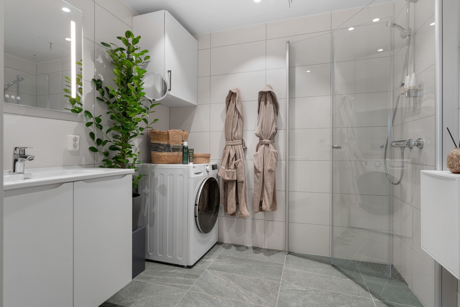 Pent og moderne bad/vaskerom med flislagt gulv og vegger, downlights i himling samt behagelig gulvvarme. Galleribilde