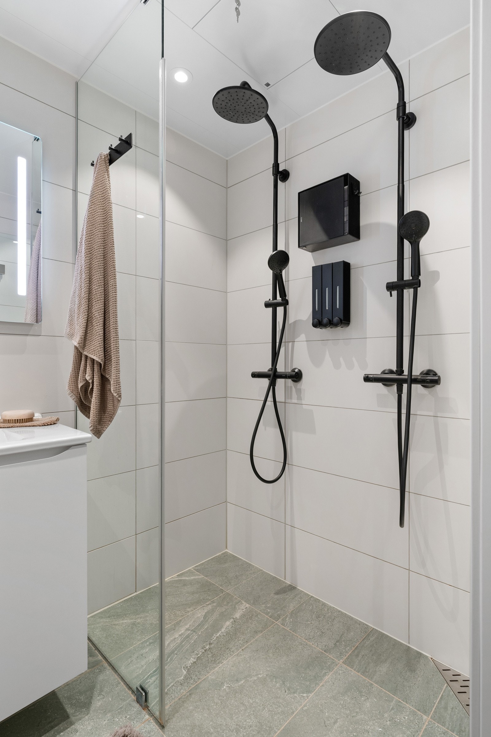 Badet er innredet med to regnfallsdusjer i sort utførelse som gir en eksklusiv spaopplevelse. Galleribilde