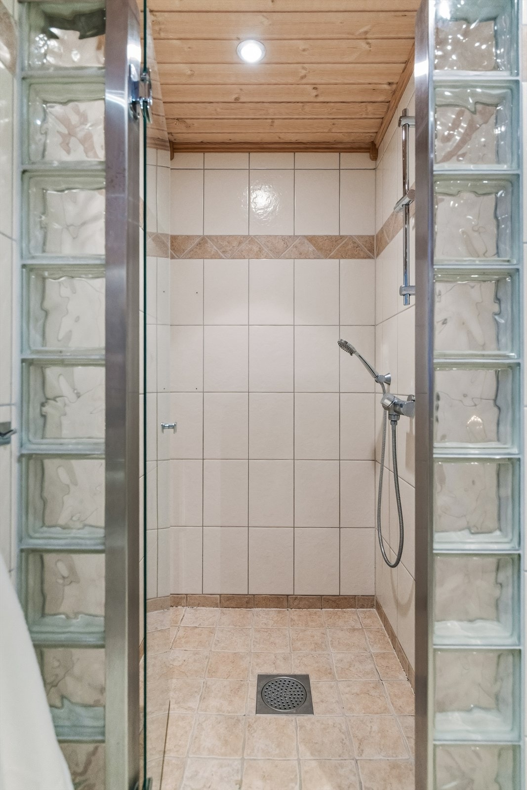 Dusjhjørne med glassbyggersteinsvegg og glassdør. Galleribilde