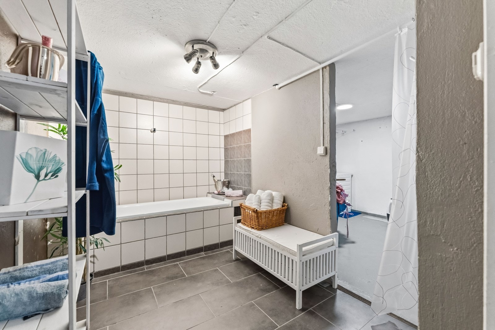 Bad med vaskerom innenfor i kjelleren. Baderomsdelen har delvis flislagte vegger og flislagt gulv. Galleribilde