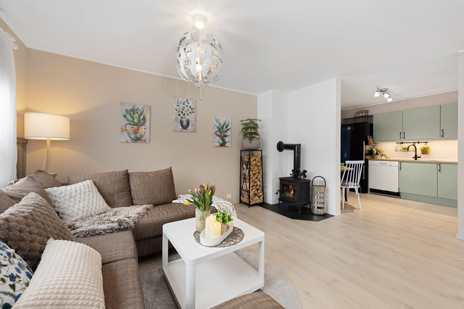 Leiligheten har en delvis åpen stue- og kjøkkenløsning malt i duse fargetoner. Galleribilde