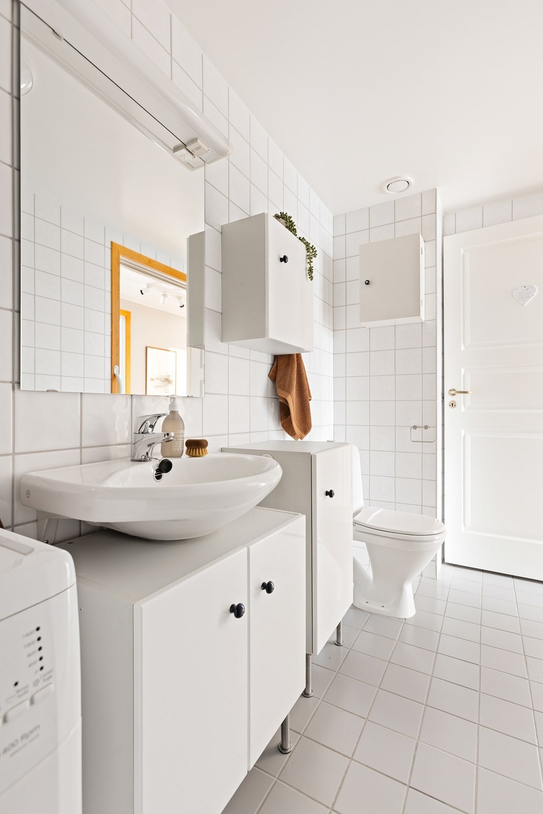 Badet er utstyrt med servant med underskap og vegghengte skap for oppbevaring. Galleribilde