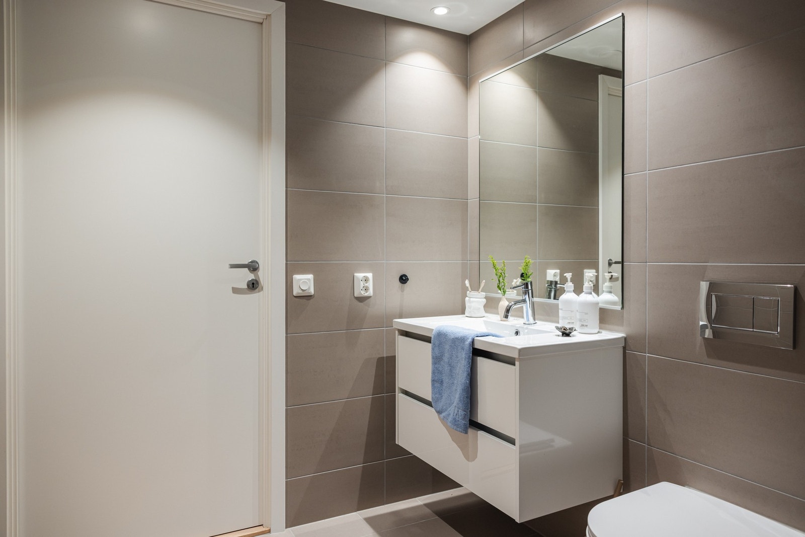 Vegghengt toalett og dusjgarnityr fra anerkjente Grohe og fliser på gulv med varme i gulvstøp. Galleribilde