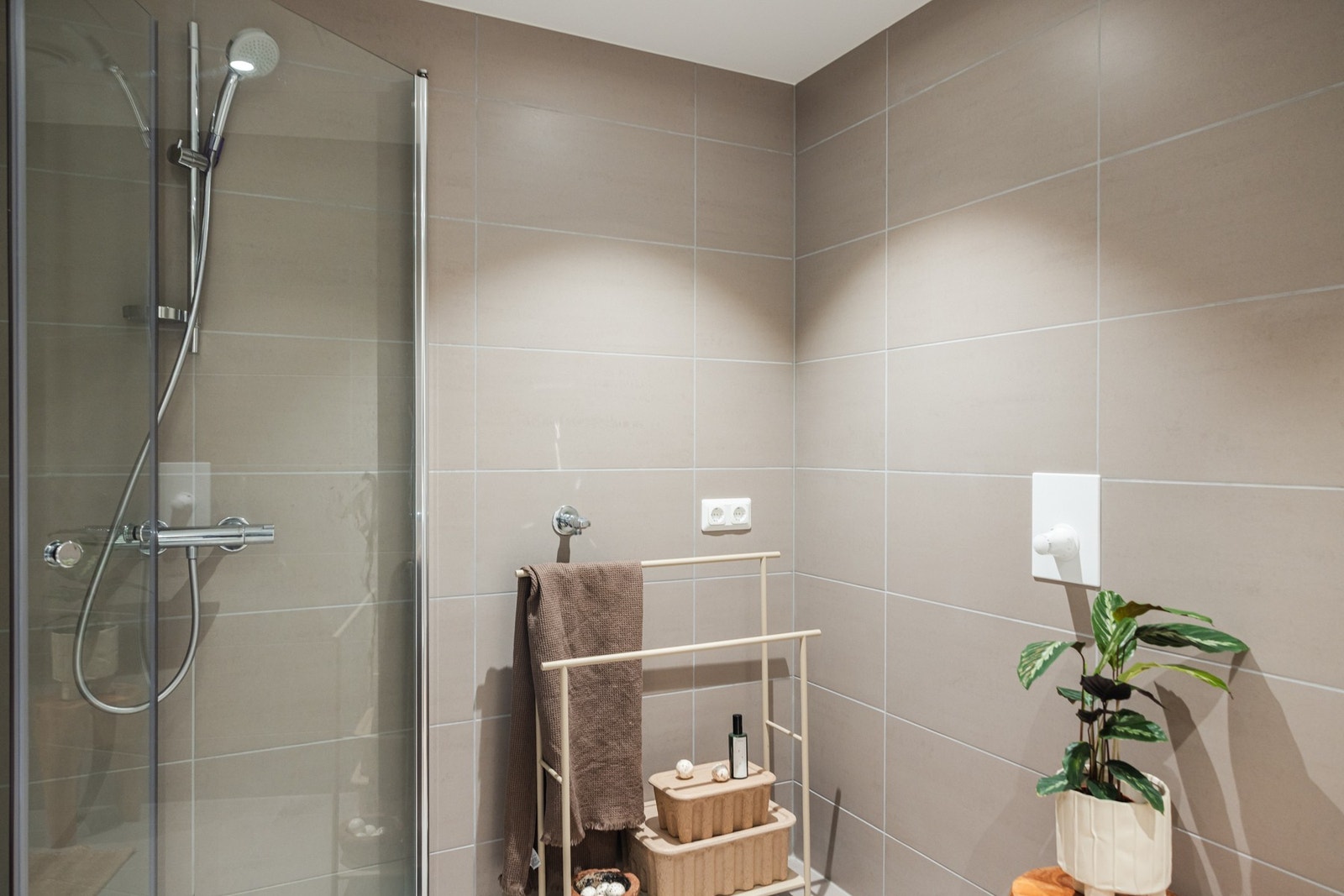 Veggene er kledd i Pavigres Grespor Minos Dawn 30x60, montert liggende for et stramt og moderne preg. Galleribilde