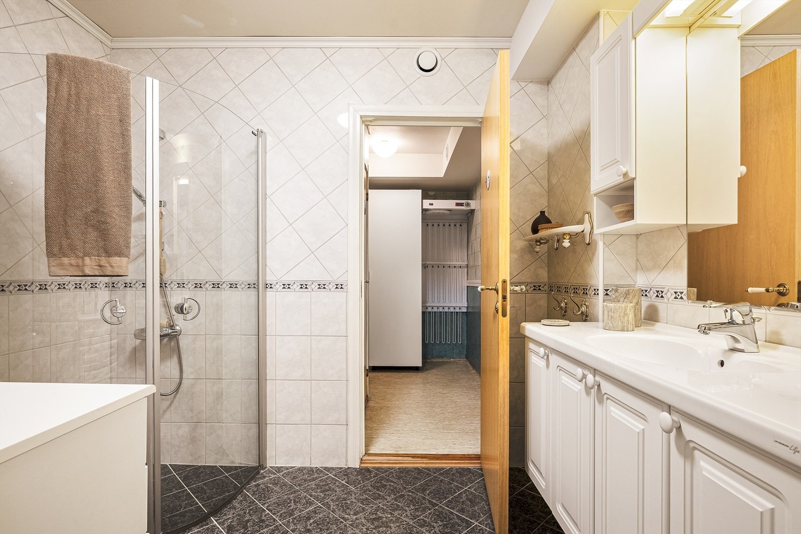 Lyst og romslig bad med lys innredning, praktisk dusjhjørne og godt med skapplass. Badet er på 5,3m². Galleribilde