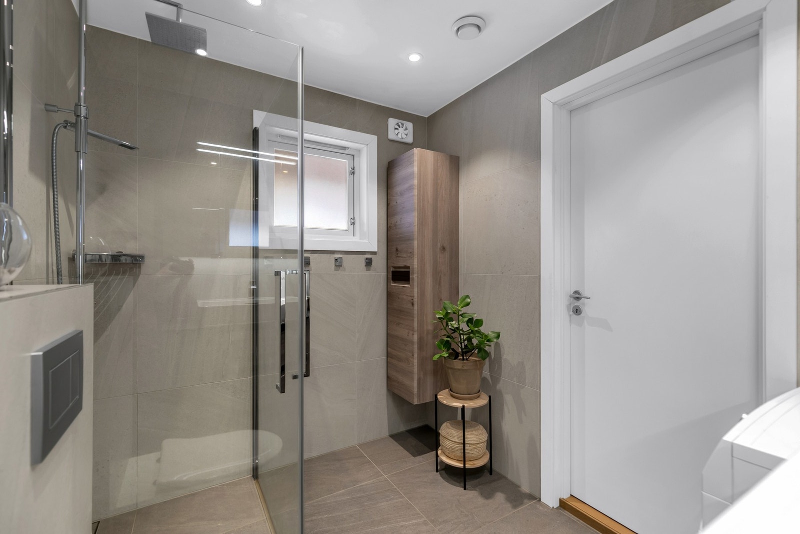 Opplegg for vaskemaskin, fliser på gulv- og vegger. Nedsenket himling med downlights. Det er varmekabler på badet Galleribilde