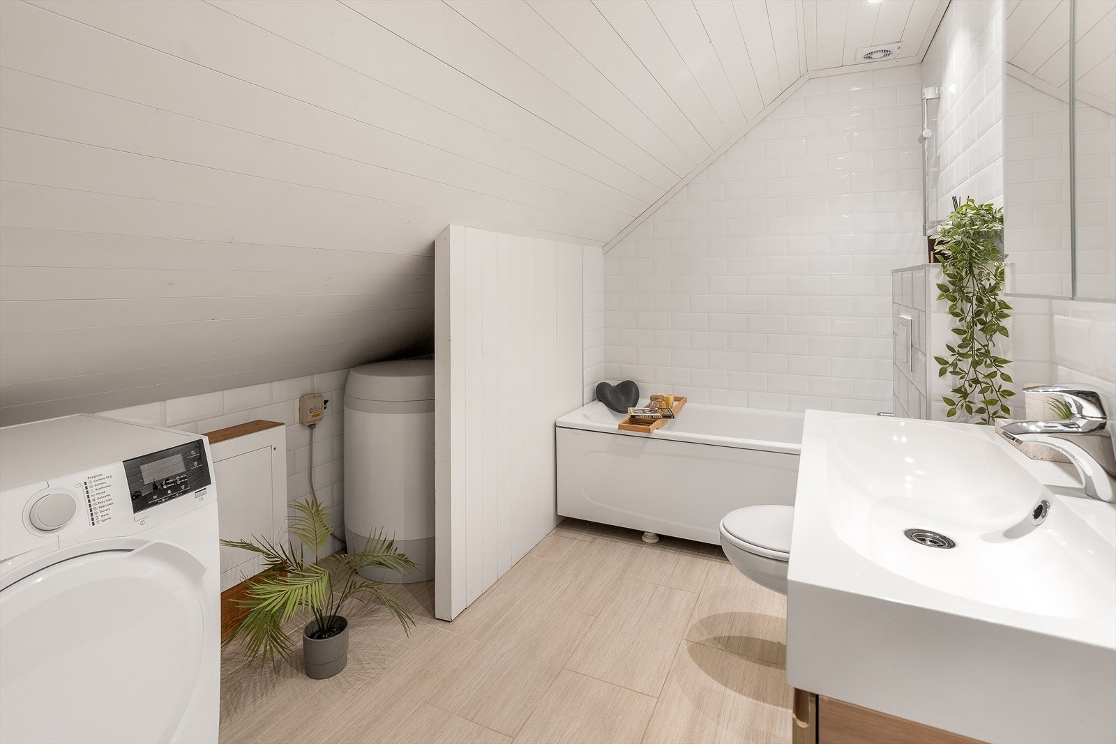 Her finner du opplegg for vaskemaskin, innredning med servant, badekar og veggmontert toalett. Galleribilde