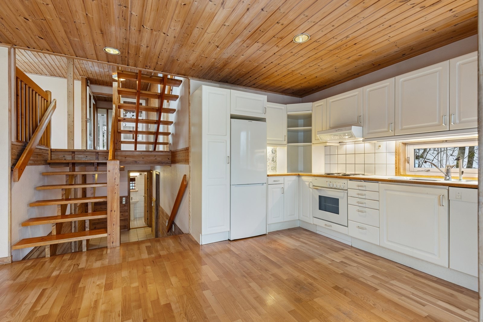 Ned en halv-etasje kommer man til kjøkken og spisestue, perfekt for både hverdagsmåltider og større selskap. Galleribilde