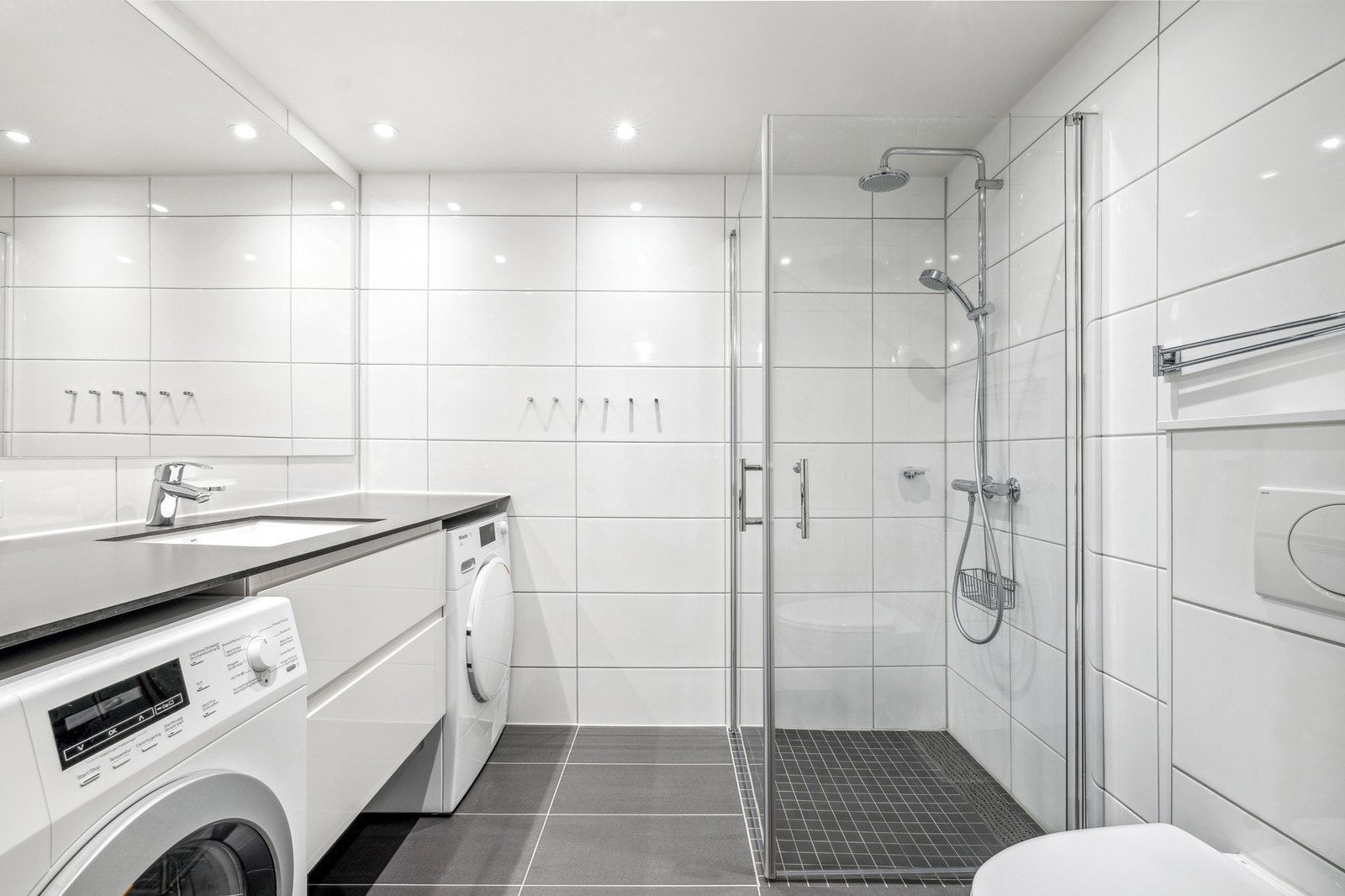 Delikat flislagt bad med medfølgende hvitevarer Galleribilde