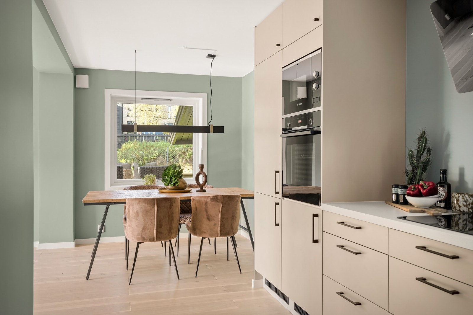 Den åpne forbindelsen mot kjøkkenet gjør det enkelt å dekke på og skaper en naturlig flyt mellom matlaging og servering. Galleribilde