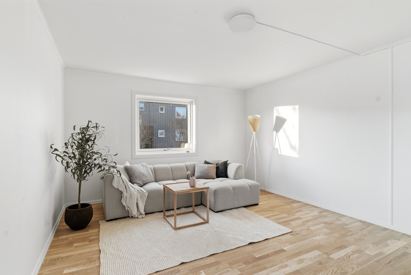 Stuen har lyse, moderne overflater og fremstår som et sosialt og trivelig oppholdsrom Galleribilde