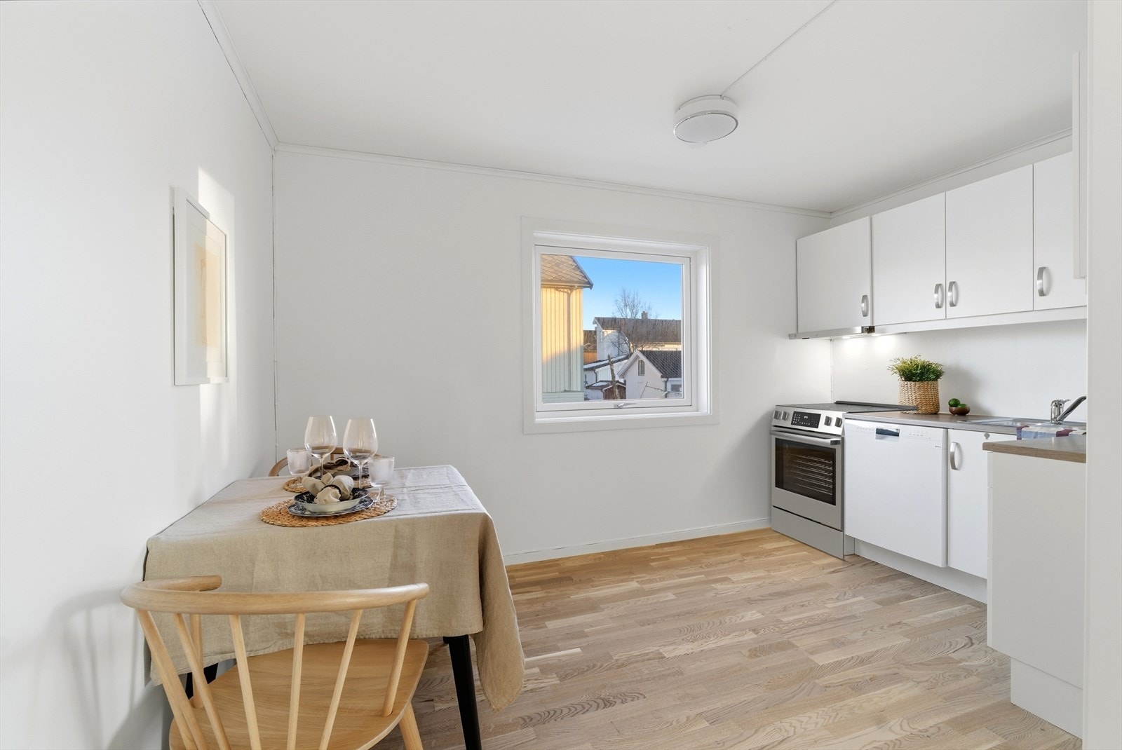 Praktisk og stilrent kjøkken med hvit, slett innredning som gir et tidløst uttrykk Galleribilde