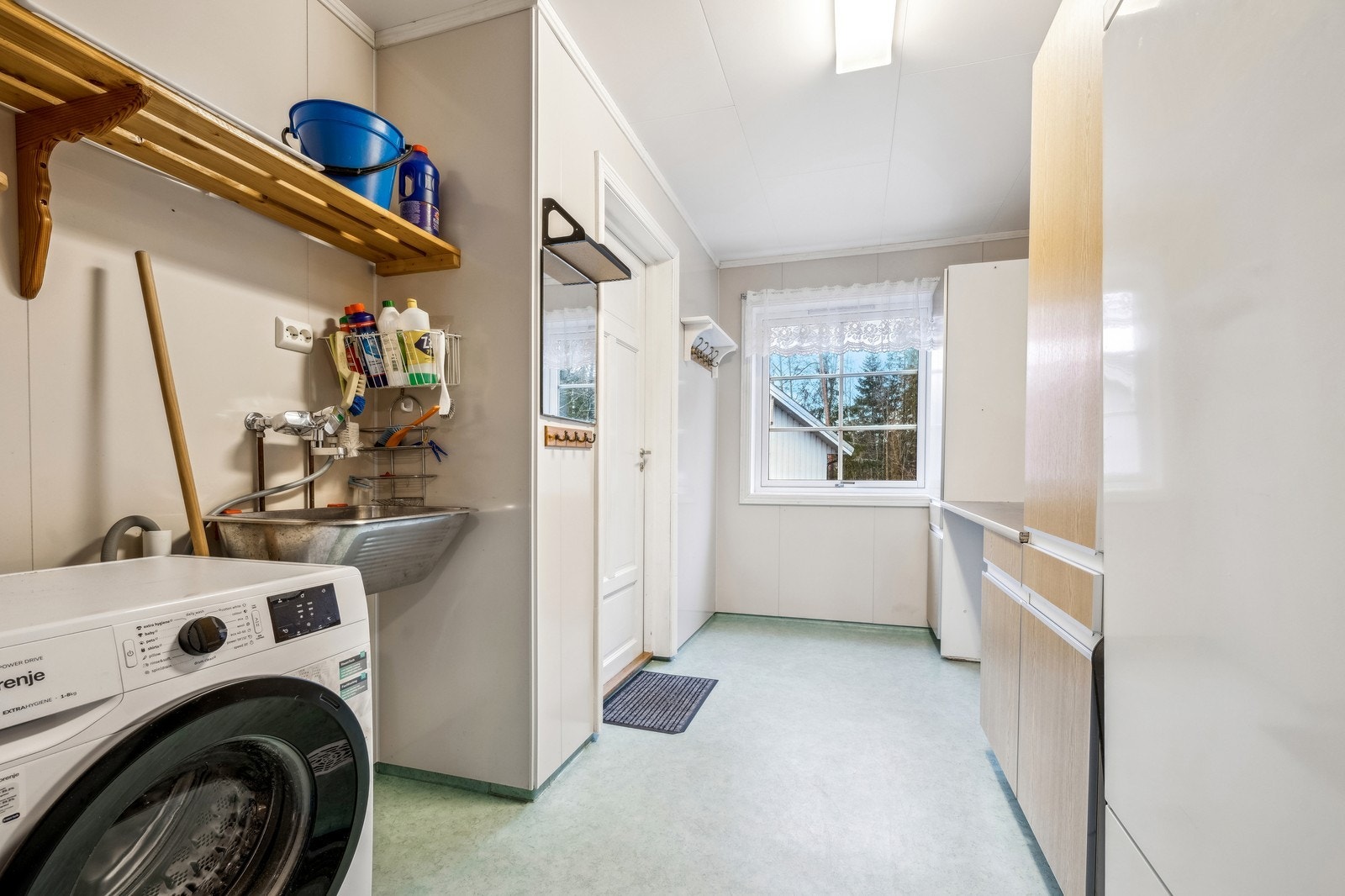 vaskerom med vaskemaskin og ekstra hvitevarer som kjøl og frys Galleribilde