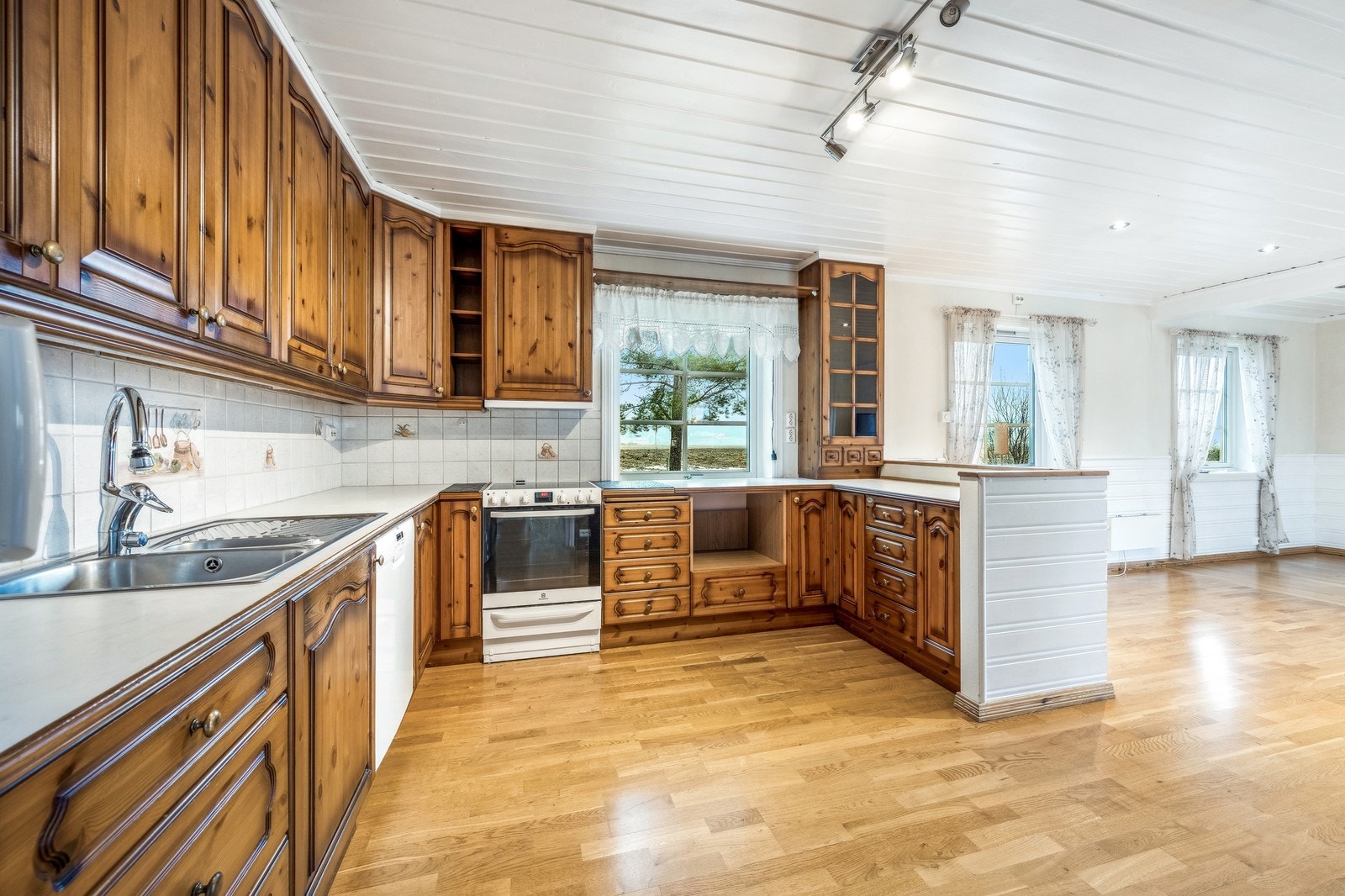 Stort kjøkken med frittstående hvitevarer og en kjøkkenøy. Frittstående hvitevarer medfølger Galleribilde